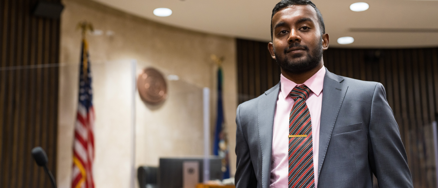 Law School Partnerships Banner Man in suit standing in courtroom
