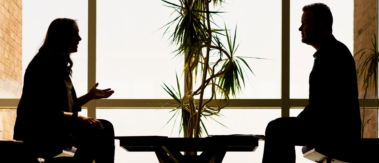 SBA-23273_Subpage_BusLeader.jpg The silhouette of two people seated across a table from each other, talking.