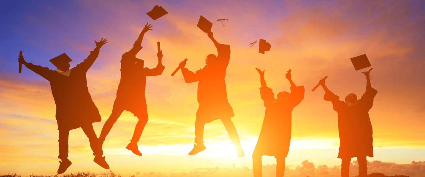 Graduates celebrate their success by jumping and tossing hats into the air, fram