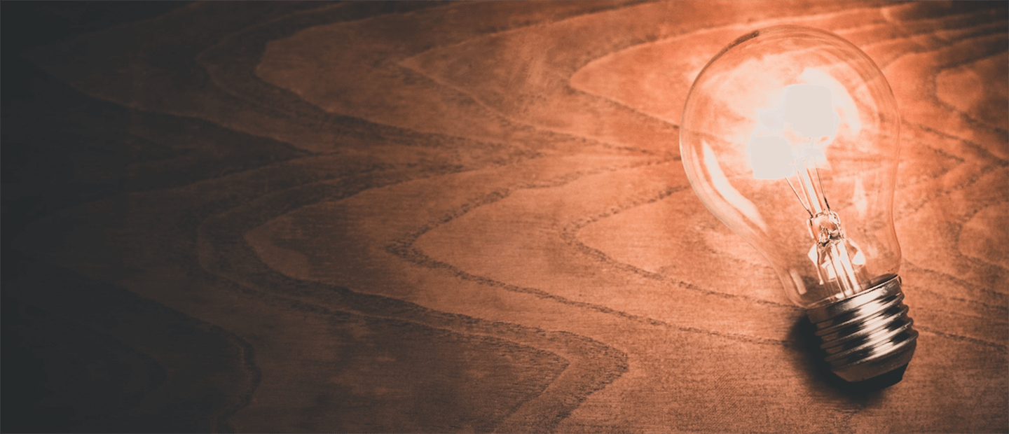 Teaching Tips Banner A lightbulb emitting light, laying on a desk
