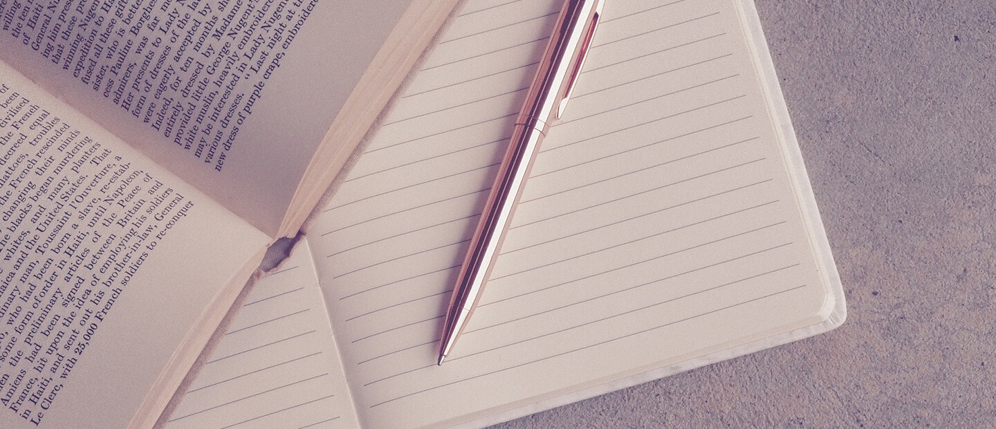 pencil on top of a notebook and book