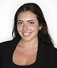 Woman with long dark hair smiling and looking at the camera wearing a black shirt.