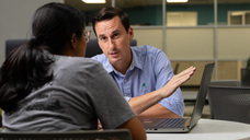 Michael Wnuk seated across the table from a woman with a laptop