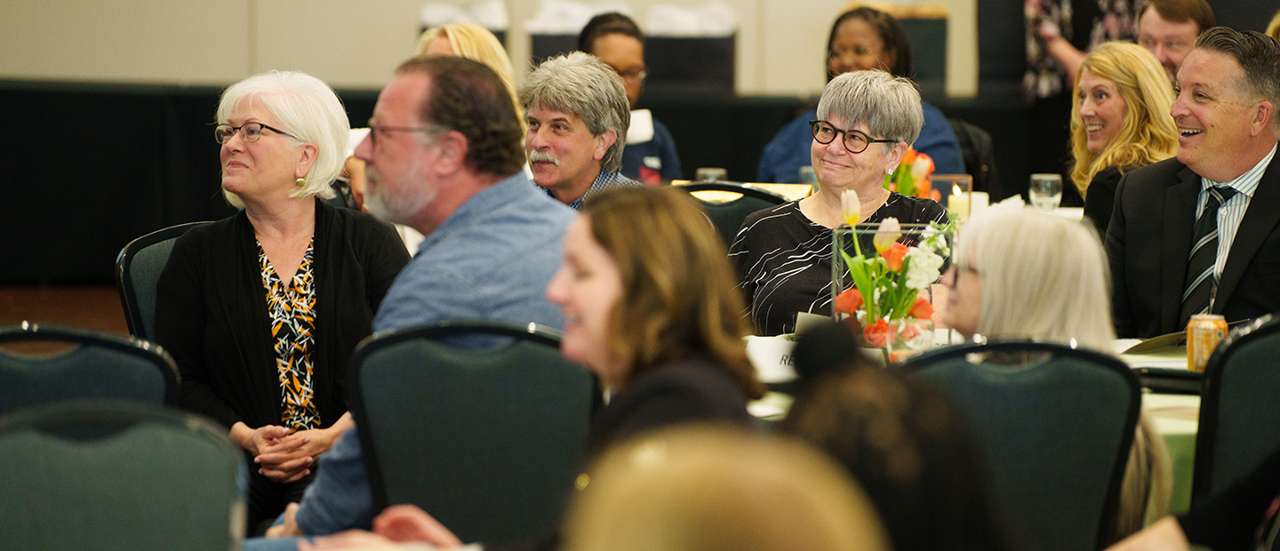 Employee Resources A table full of OU employees engaged with a speaker at the front of the room