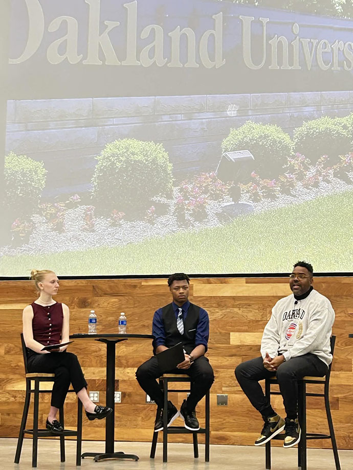 Stefen Welch talks with two Oakland students.