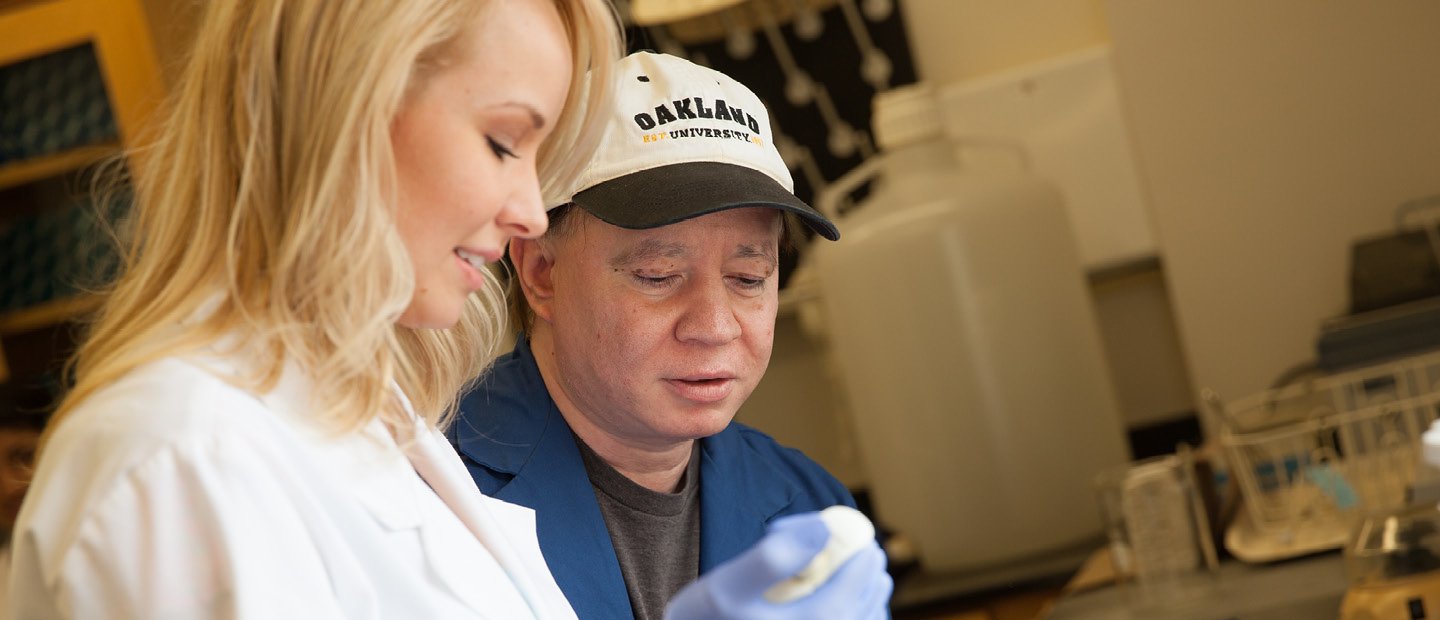 Research Office Banner man in a hat and woman in a white coat working in a lab