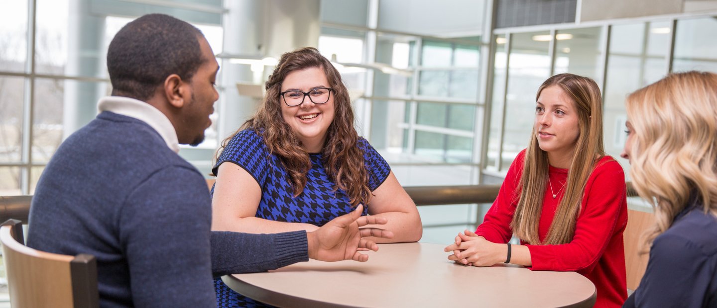 Non-degree.jpg four students seated at a table with windows behind them