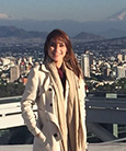 Brenda Murueta posing for a photo above a city skyline