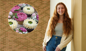 A student leans against a wall with cupcakes on the other side