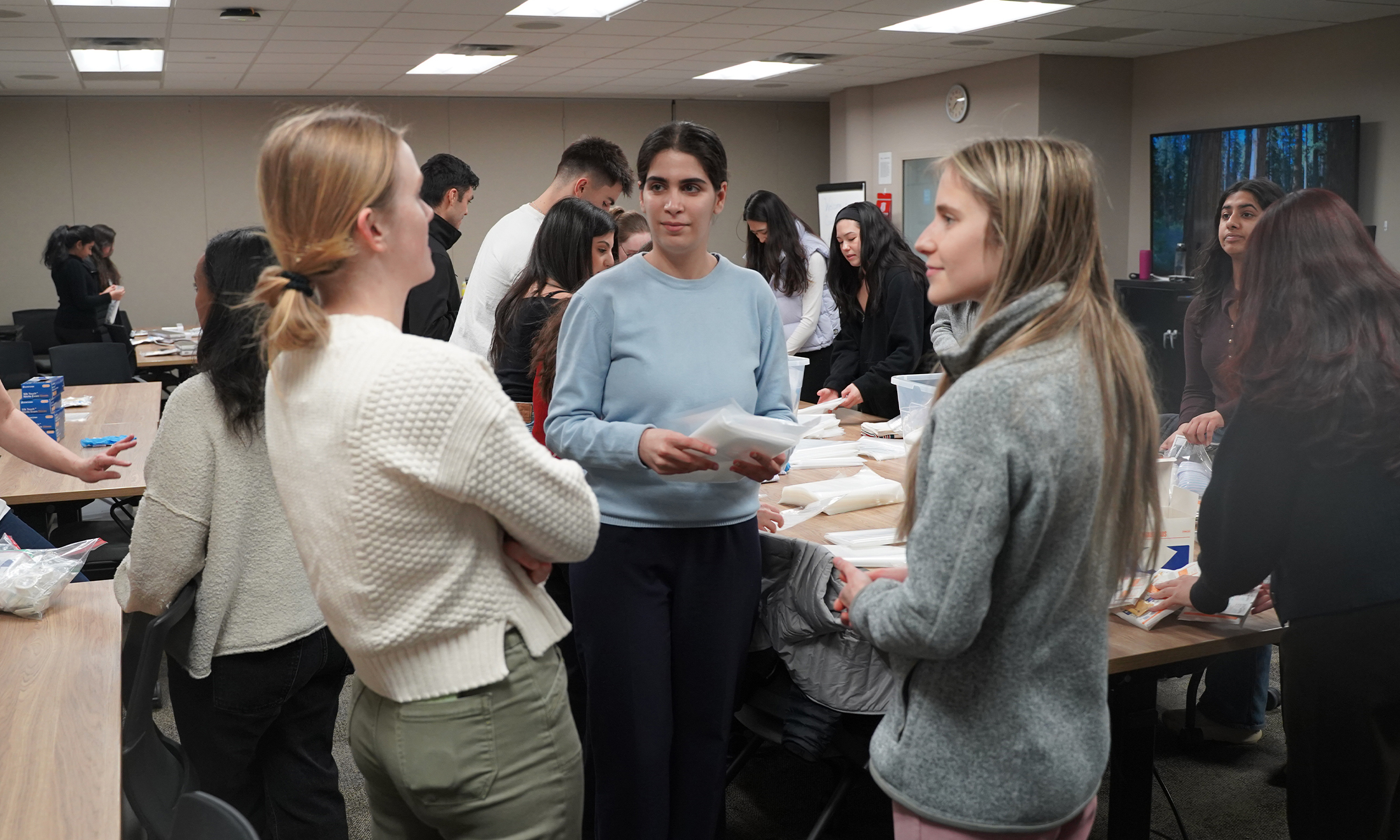 Students talk while assembling clean birth kits