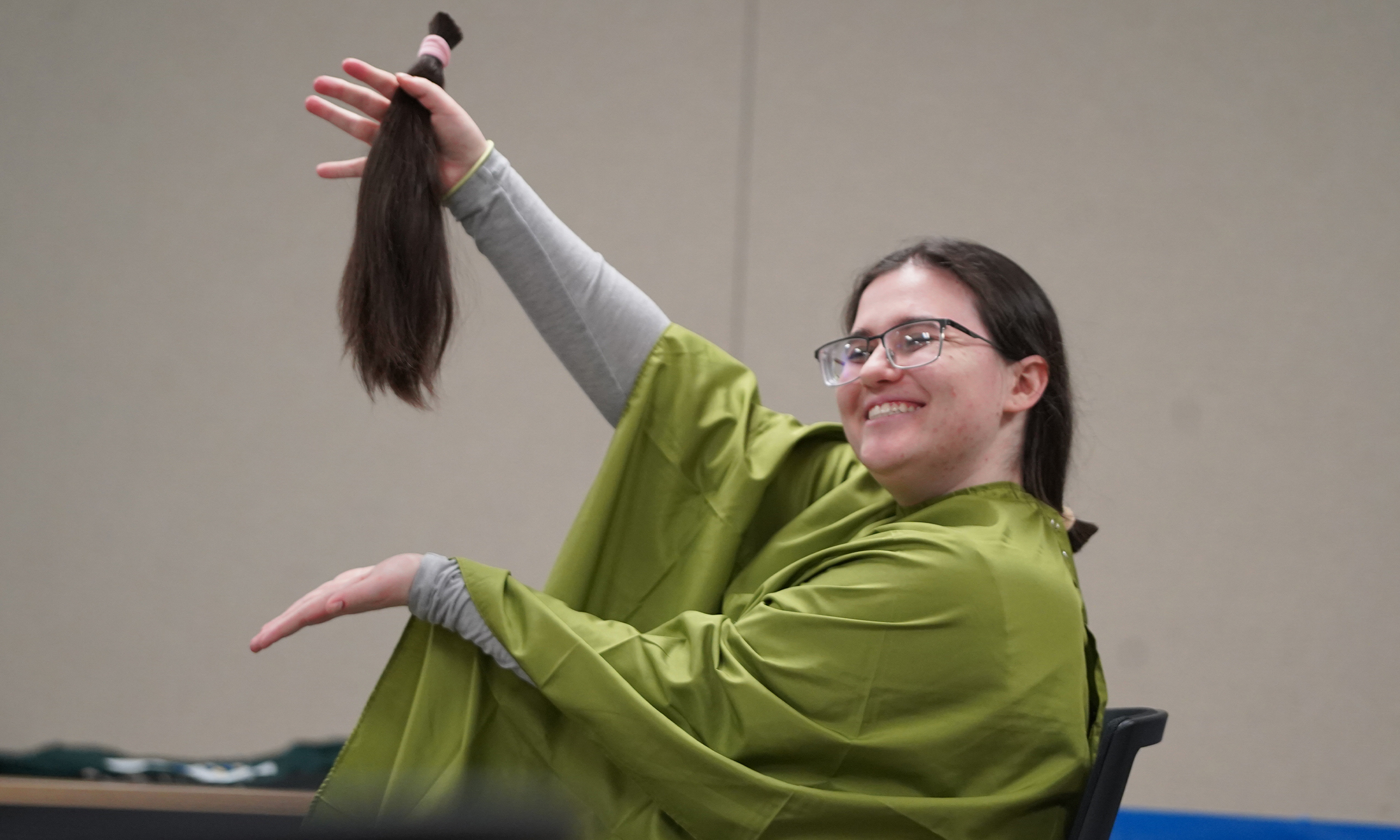Julia Freeman holds up the hair she had cut off during the event