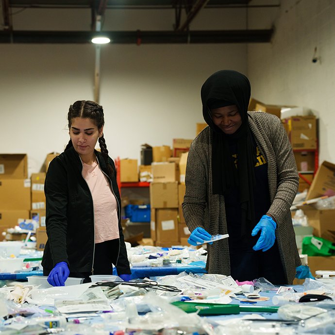 Two people sorting through medical equipment