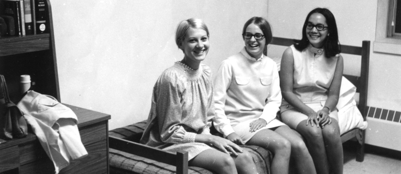 Three people sitting on a bed