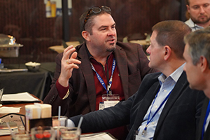 A doctor sits at a table as he answers a question