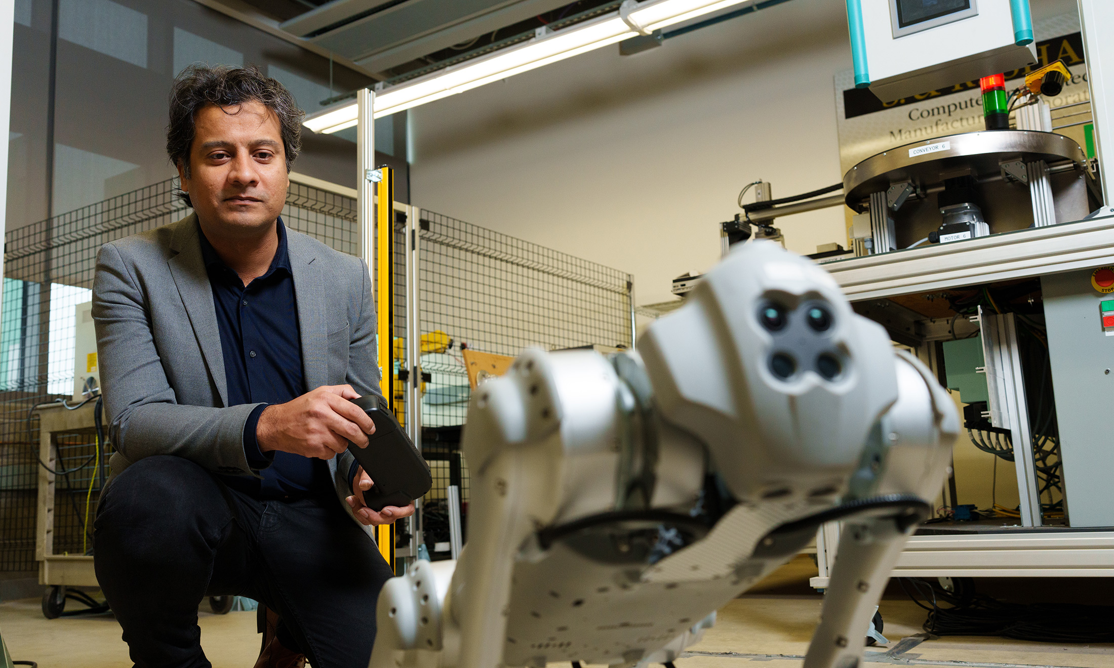 A man holding a device to control a robot-dog