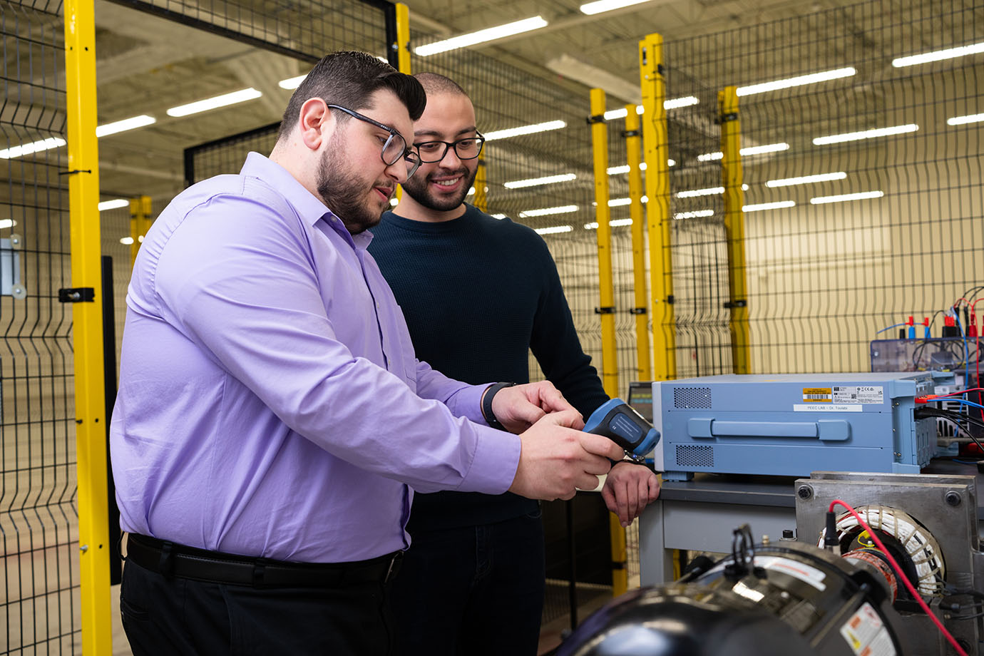 Two students working with equipment in the lab