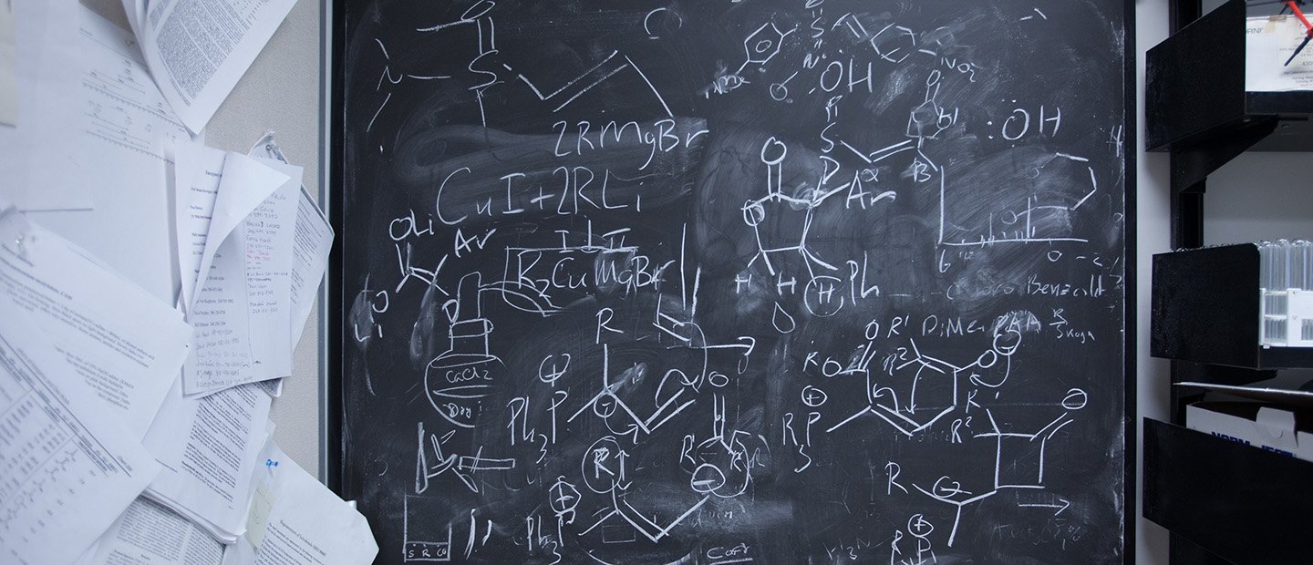 HPC Banner A chalkboard with chemical equations and diagrams written on it.