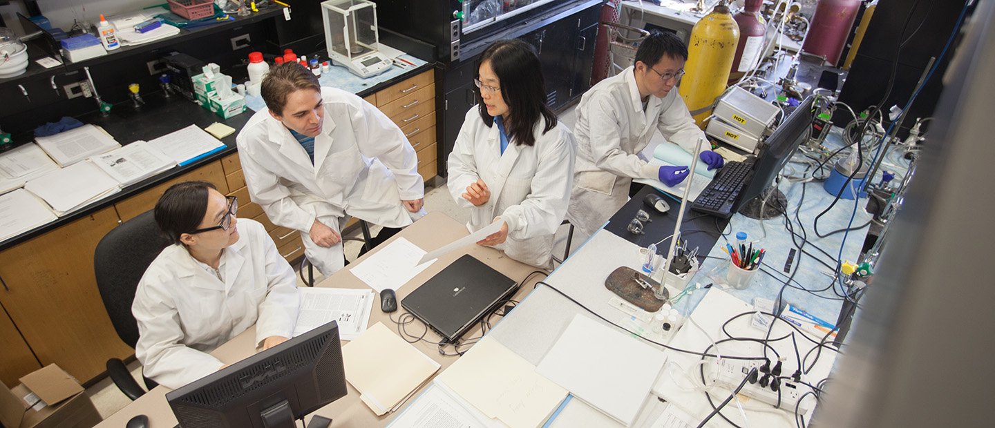Give to the Research Office Banner People in white lab coats working in a research lab.
