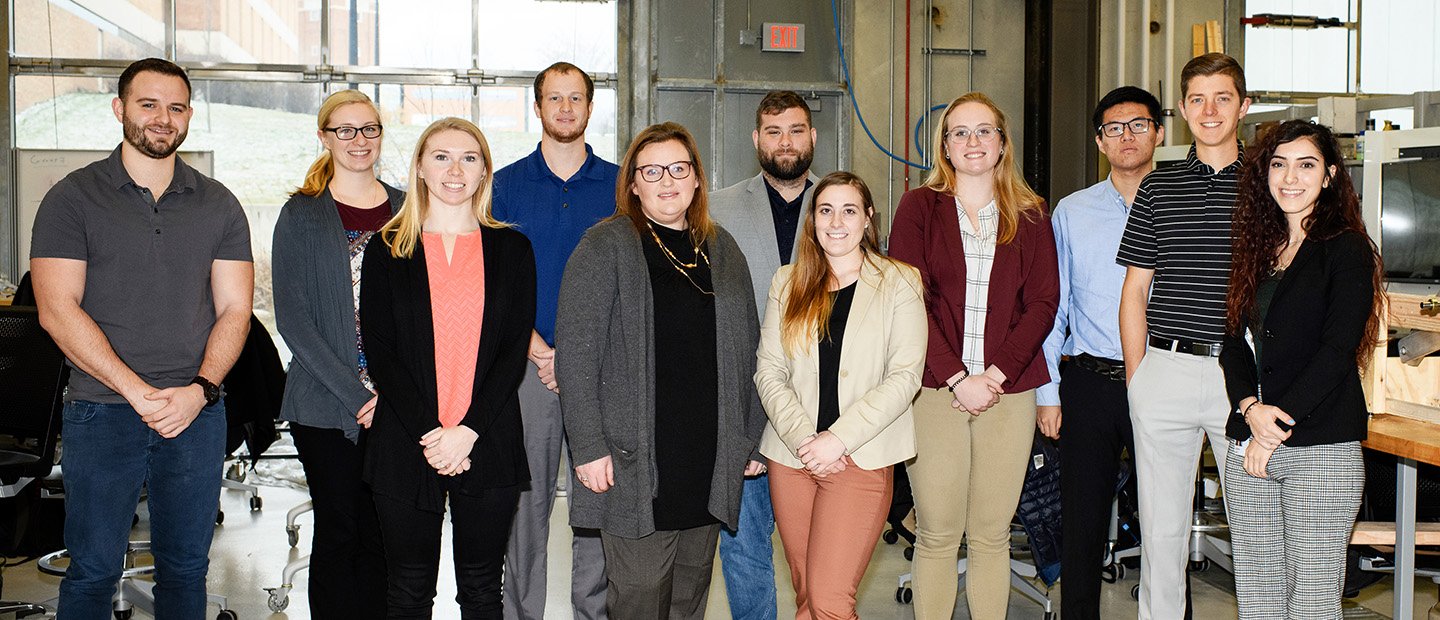 Professional Development, Collaboration Resources and Community Engagement Banne A group of people in a lab, posing for a photo.