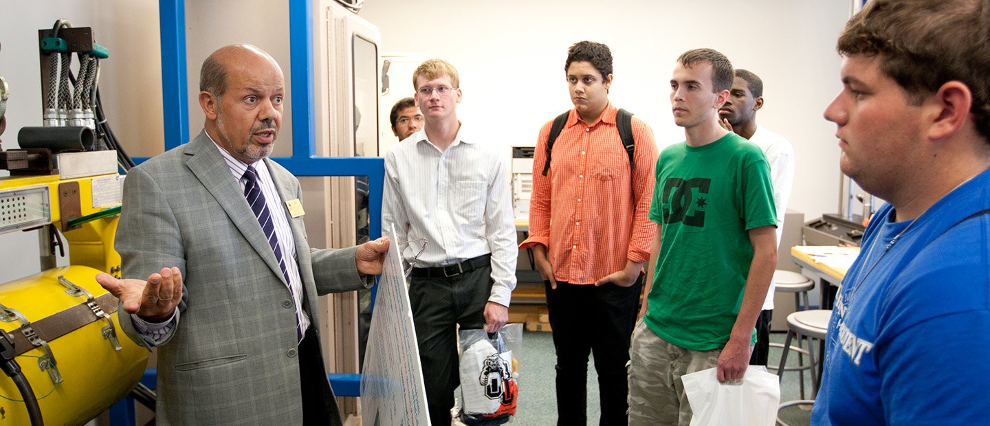 Research Centers Banner A professor talking to a group of students in a research lab.