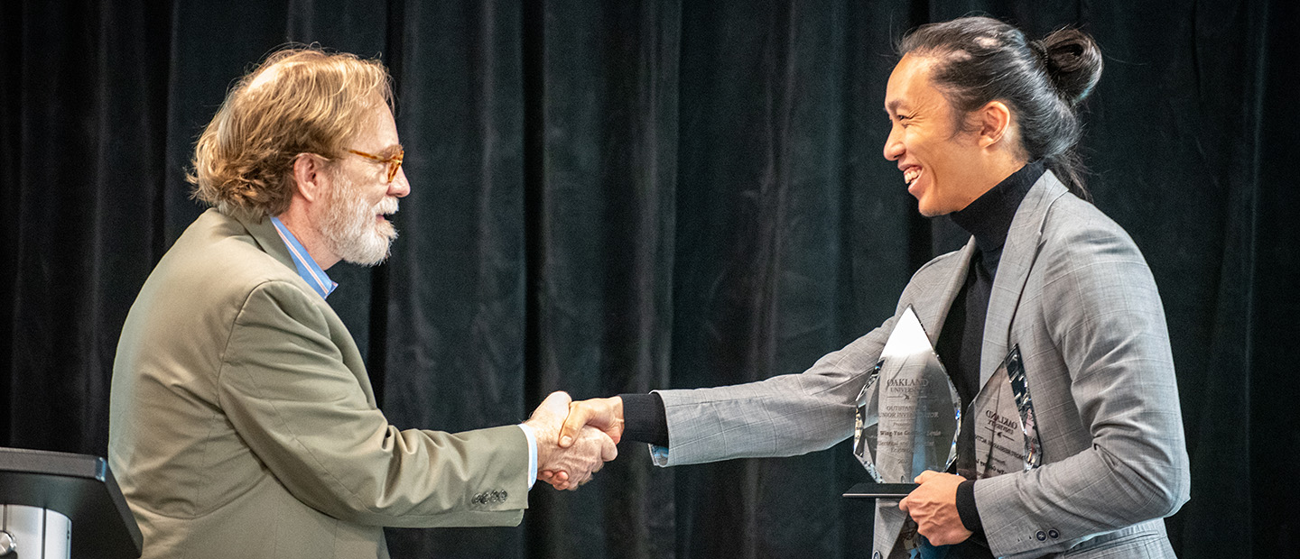 Research-related Events Banner A man presenting an award to another person.