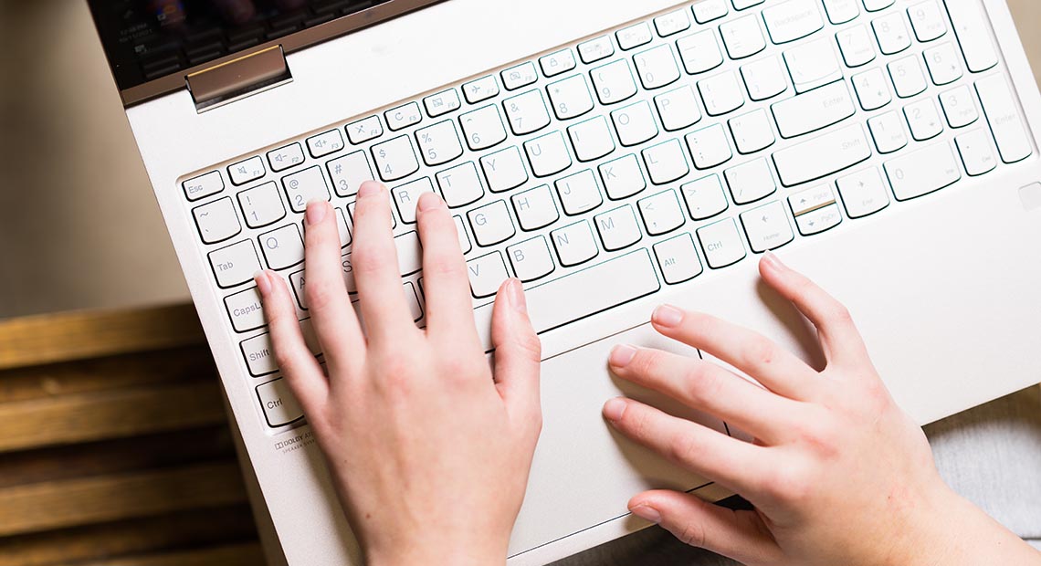 SBA-23960_048.jpg Hands typing on a laptop keyboard