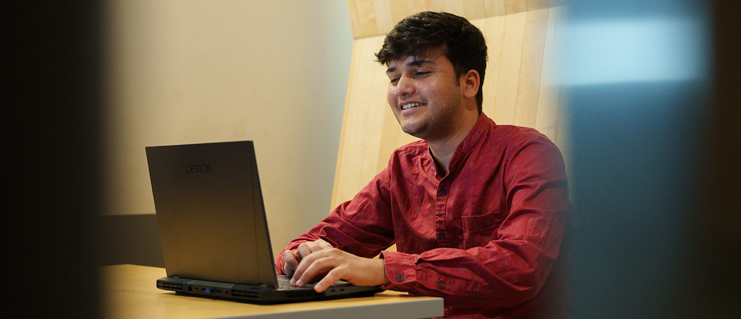 Masters Programs AI A young man working at a laptop