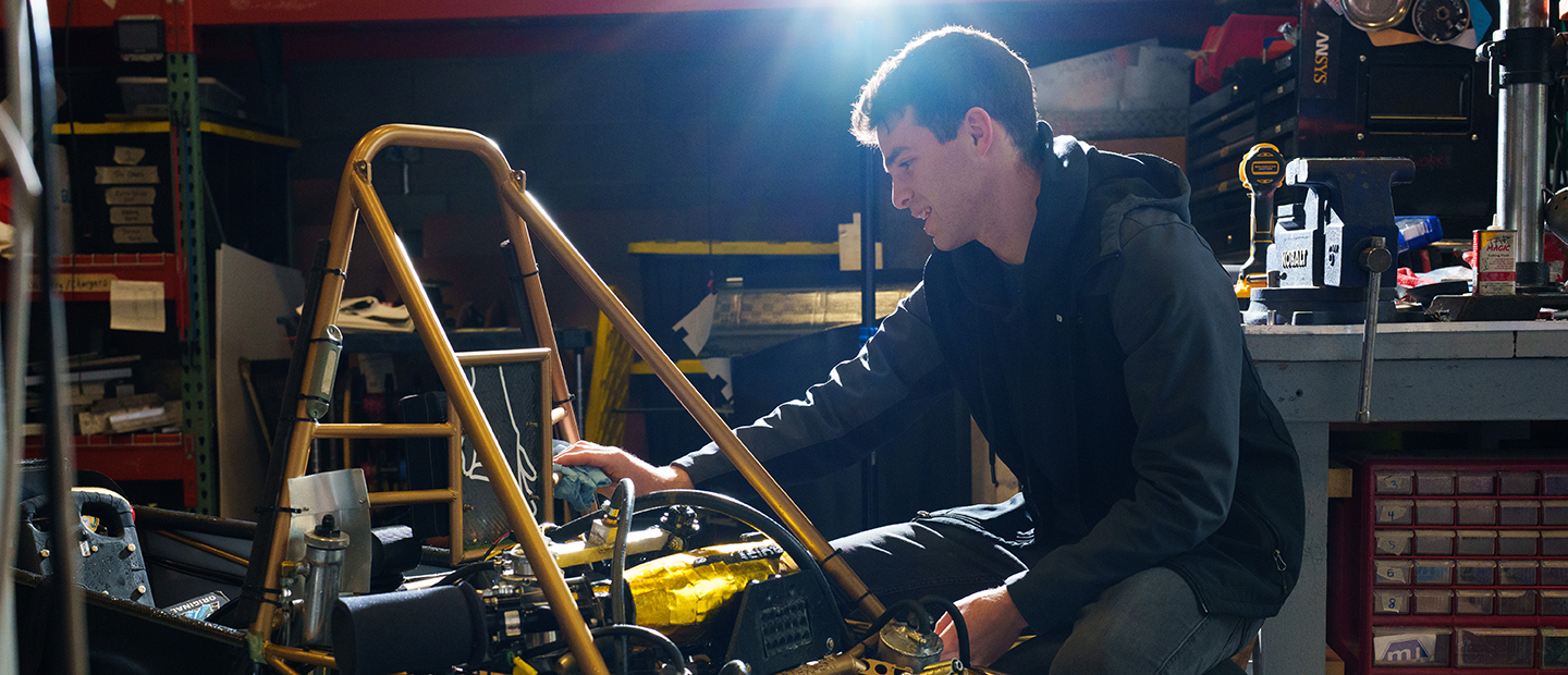 SECS Department Undergraduate Programs ME Banner A young man working on mechanical equipment
