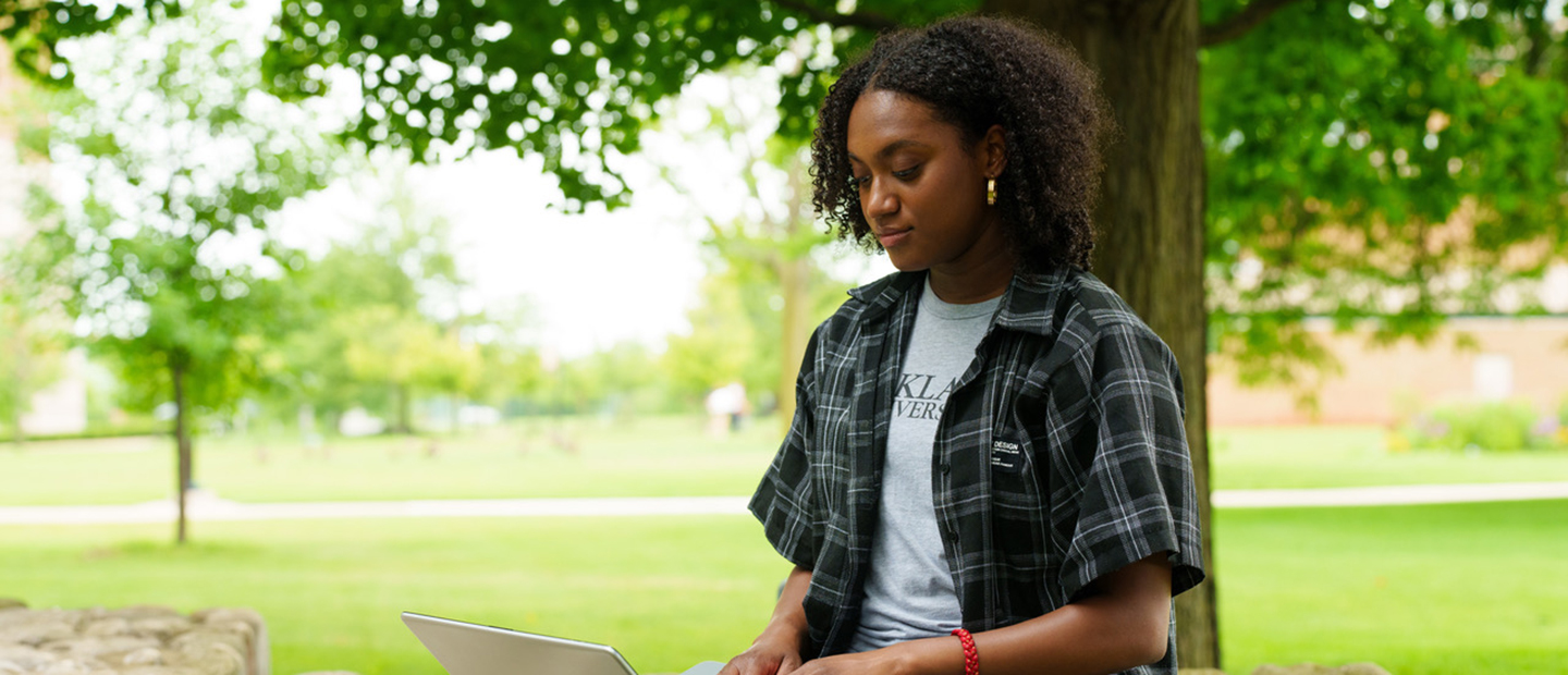 Advising Banner A student looking at a computer outside
