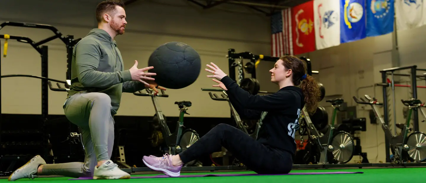 HMS Minors Two people performing partner core exercises.