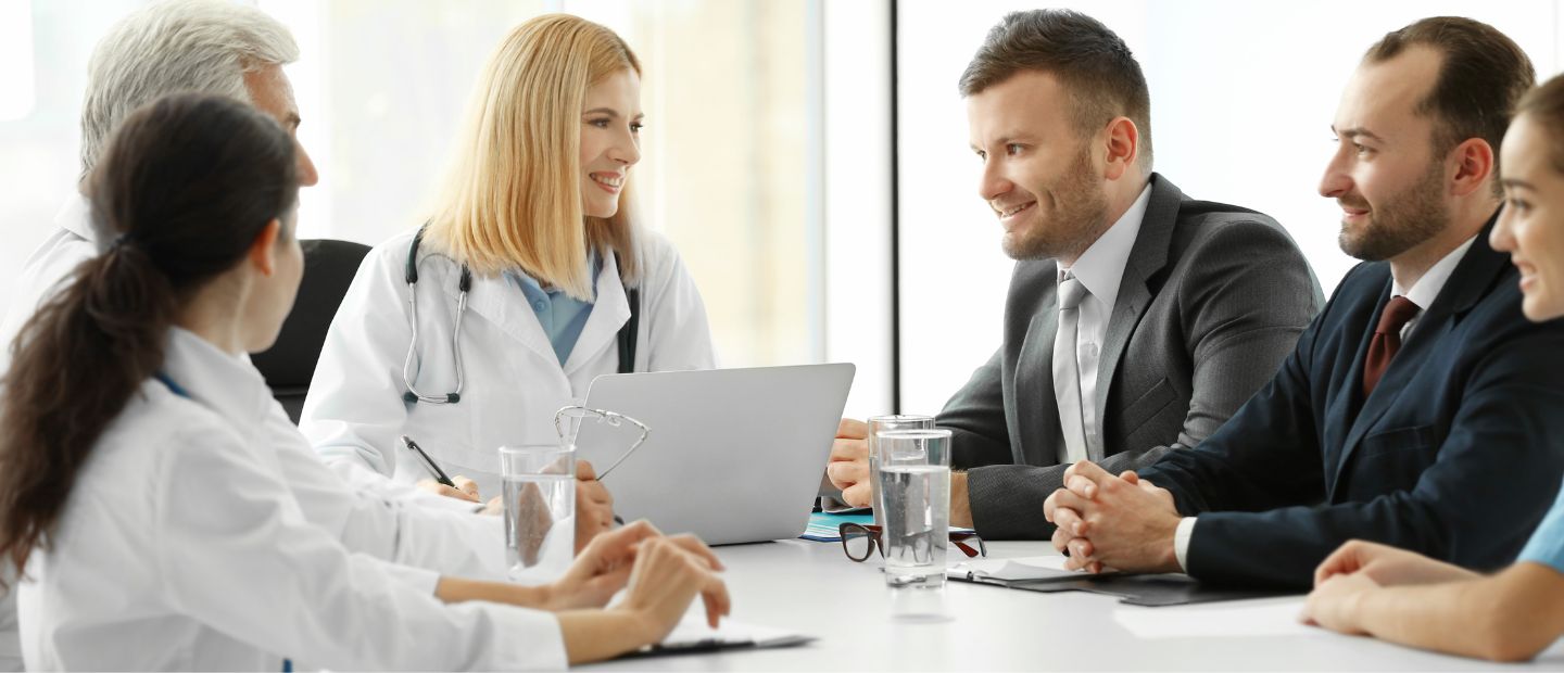 Healthcare professionals Healthcare professionals seated in a meeting room.