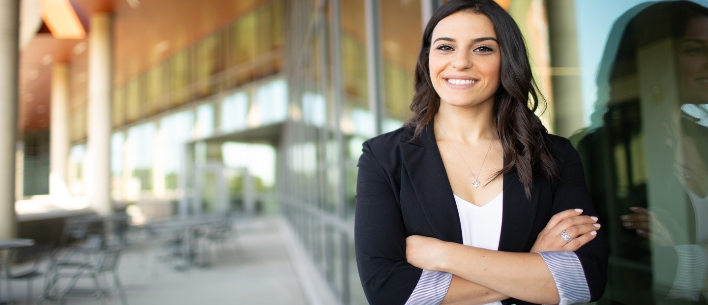 Woman smiling with arms crossed Woman standing and smiling at camera with arms crossed