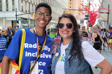 Raya Hollis smiles at the camera with a friend at an event