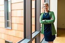 image of Kirstin Landis-Piwowar leaning against a window in the Human Health Building