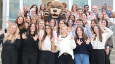 A group of Master of Physician Assistant Science students posing with the Grizz mascot.