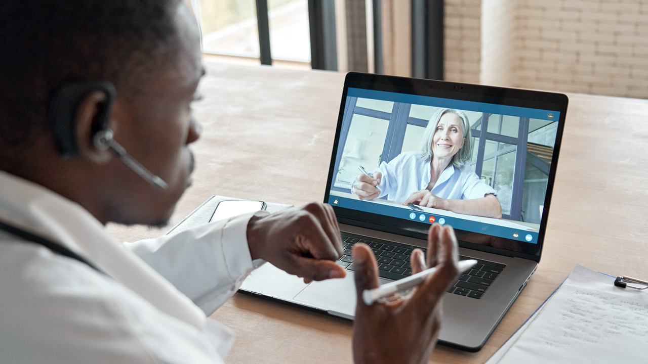 Healthcare worker conducting telehealth appointment on a laptop