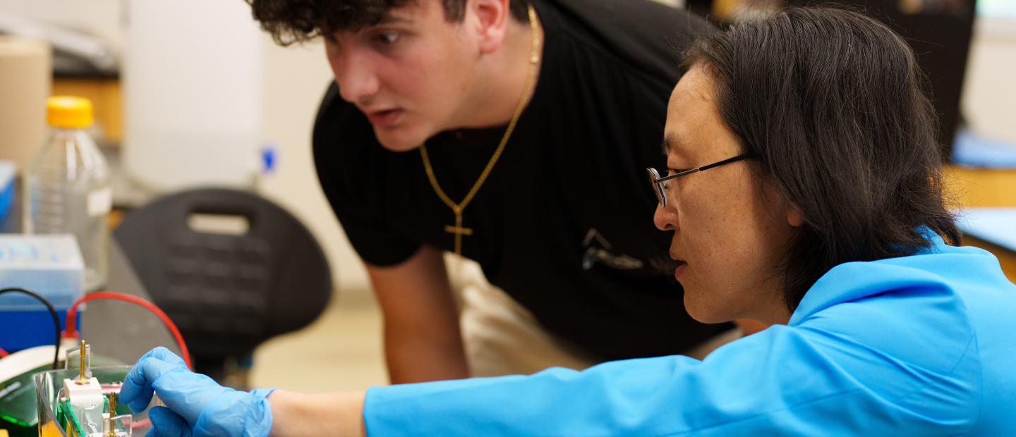 Academic Programs Two people working on a piece of equipment in a classroom