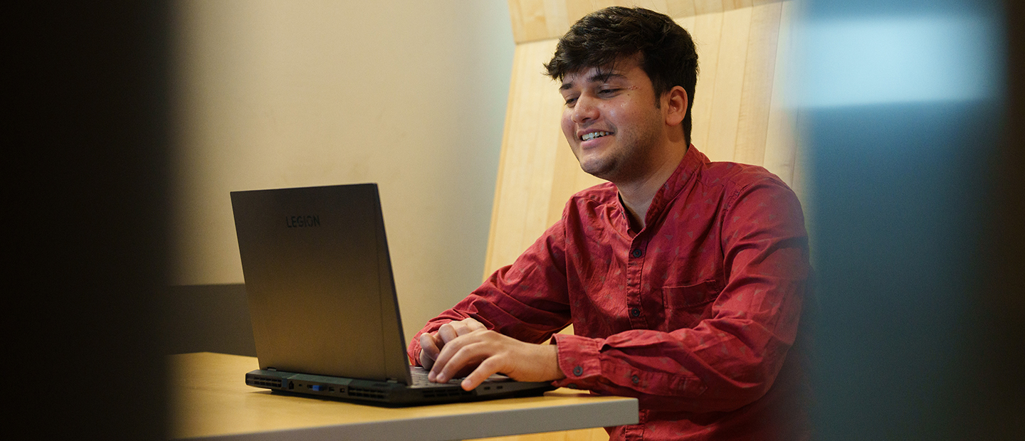 Scholarships, Costs and Aid A young man seated, working on a laptop