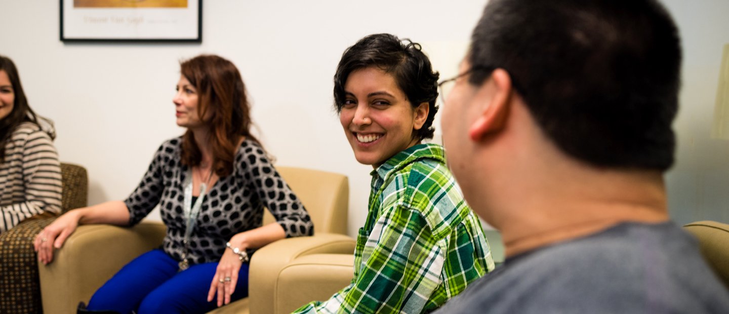 _0008_Counseling Organizations.jpg Four people seated in a row of arm chairs, smiling.