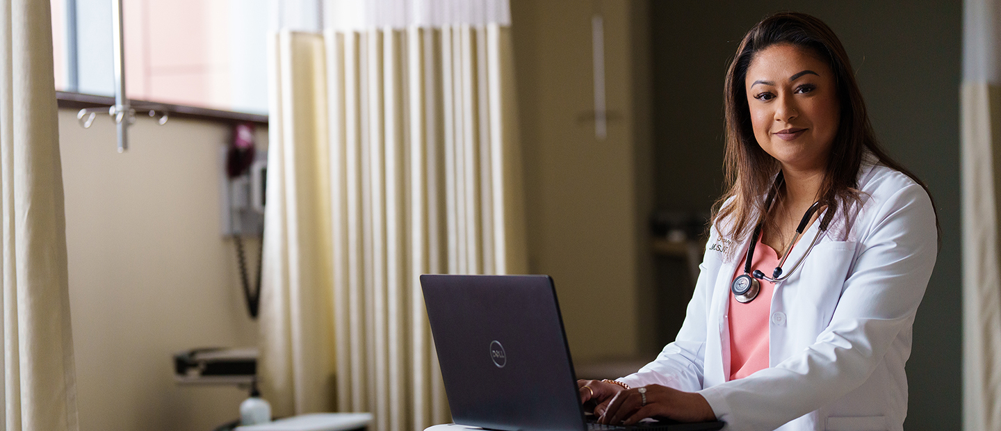 SON-25760_017 1440 620.png woman in a white lab coat with a stethoscope around her neck speaking to another woman