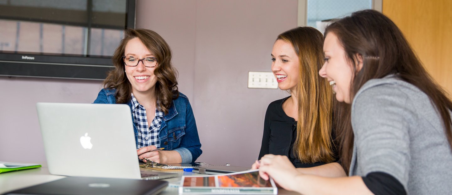 SFS Mentor Teachers.jpg Three women seated at a table, looking at a laptop together.