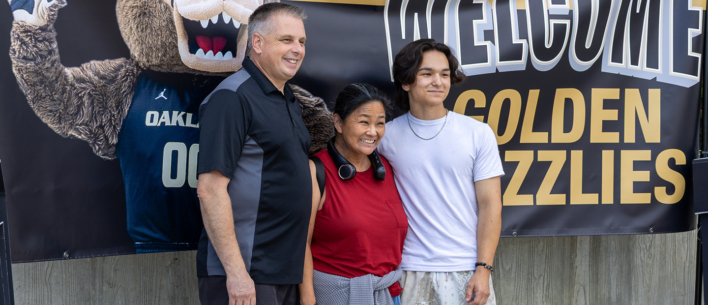 Parent and Supporter Information A new student and his parents in front of a Welcome Golden Grizzlies banner